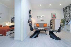 A modern living room with a sofa, two black chairs, a coffee table, and a bookshelf. - 2BR 2BA Historic Center, Metro - Comfort, Quiet (Rome)