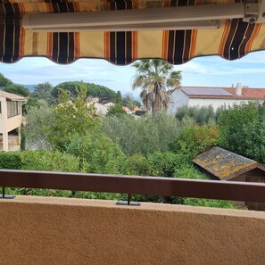 Un balcón con vista a una zona residencial, con casas y árboles.
