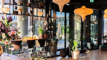 A modern interior with a bar area, seating, and large windows.