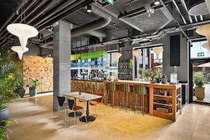 A modern interior with a bar area, seating, and a patterned wall. - Belle Guldsmeden (Aarhus)