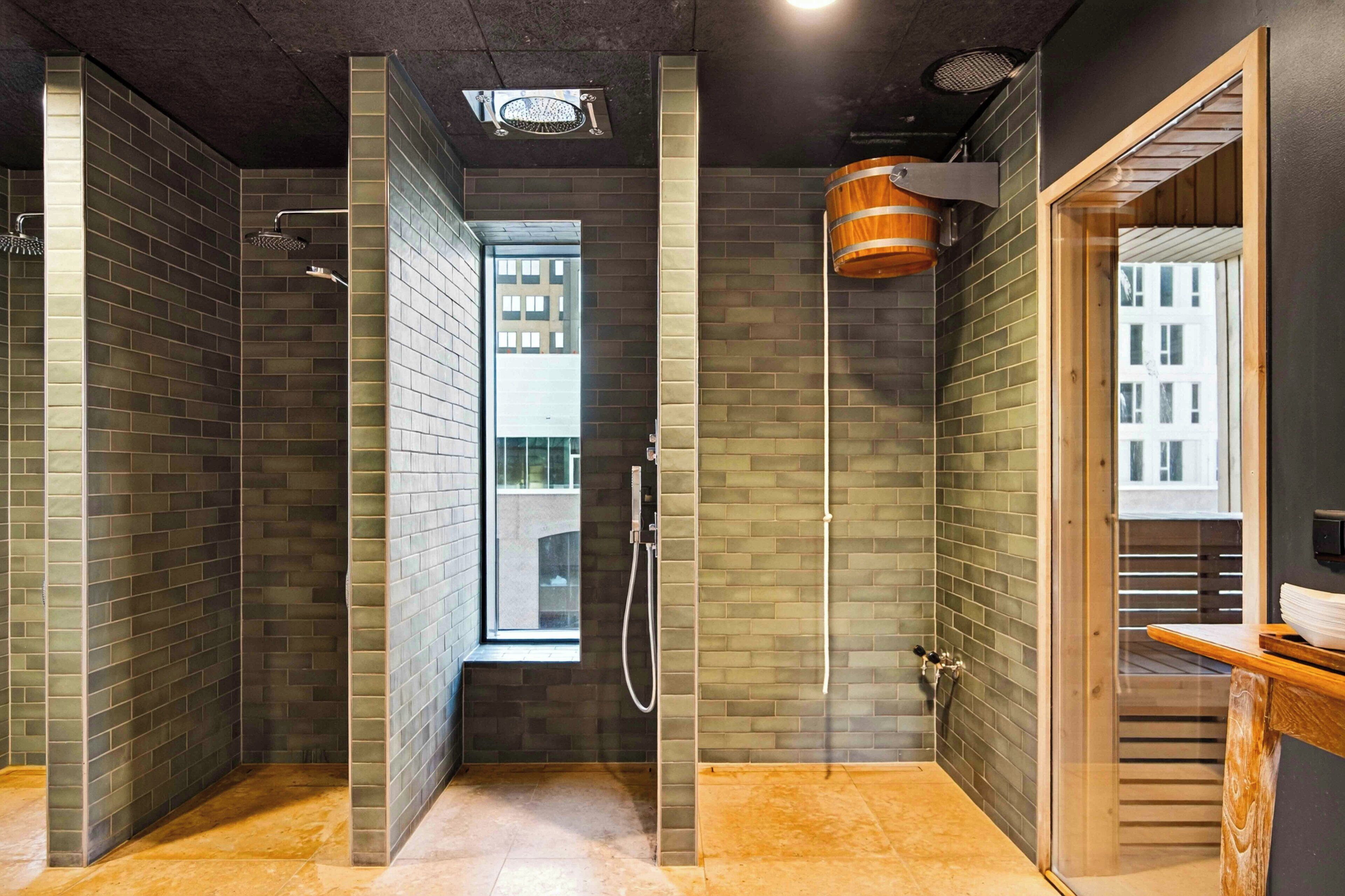 Et moderne badeværelse med bruser, toilet og håndvask.