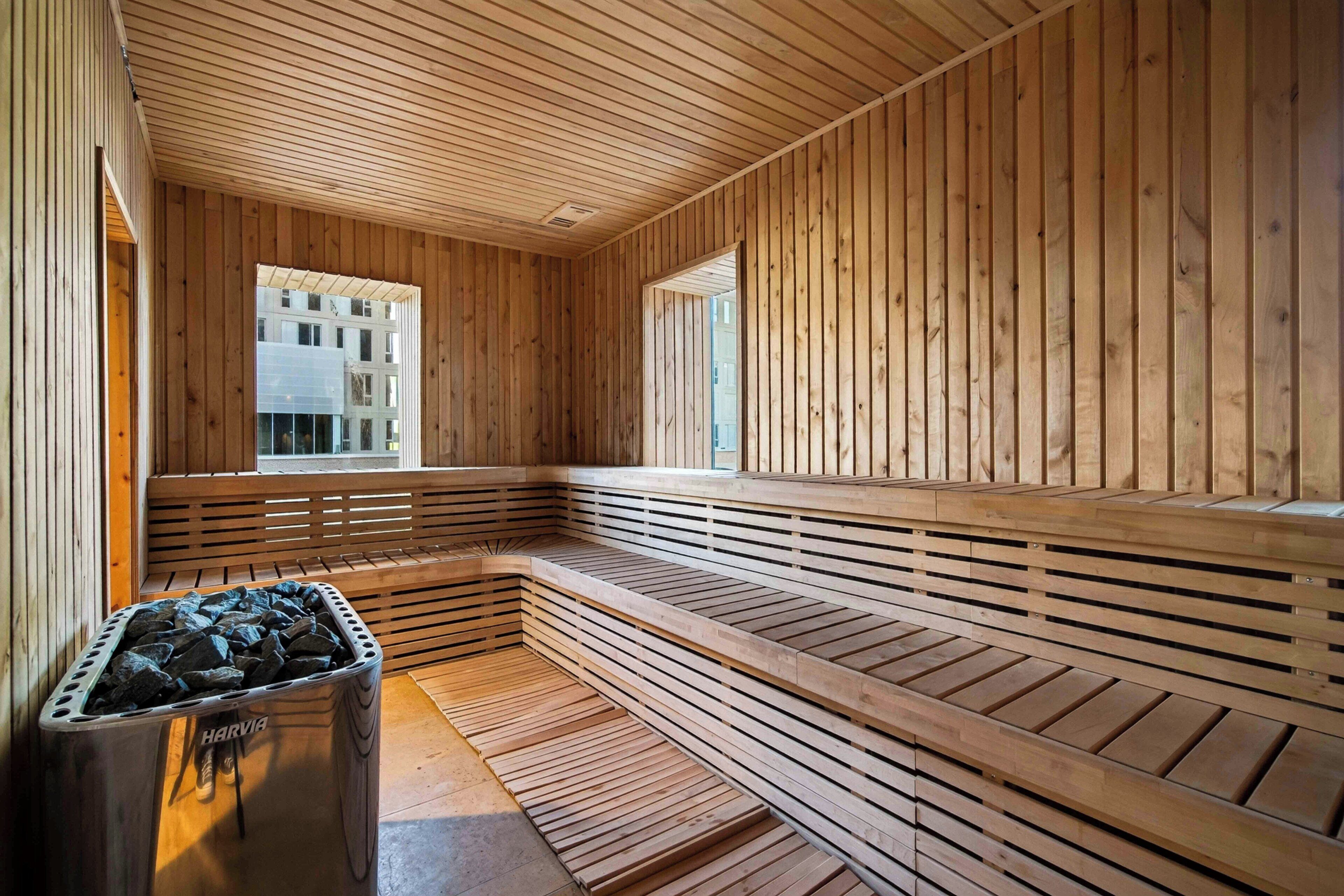A sauna with wooden benches and a stone heater.