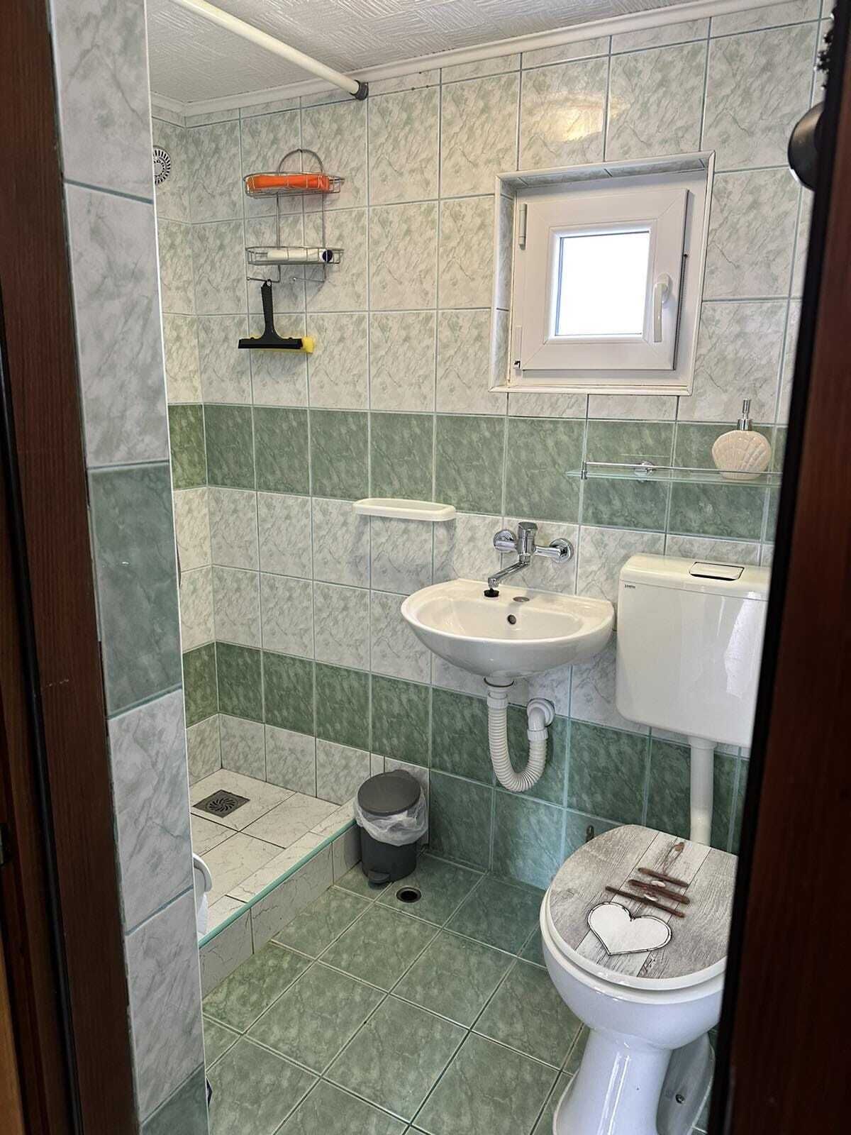 A bathroom with a sink, toilet, and shower area.