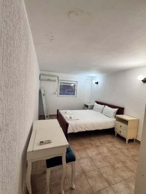 Ein Schlafzimmer mit Bett, Nachttisch und Schreibtisch mit Stuhl.