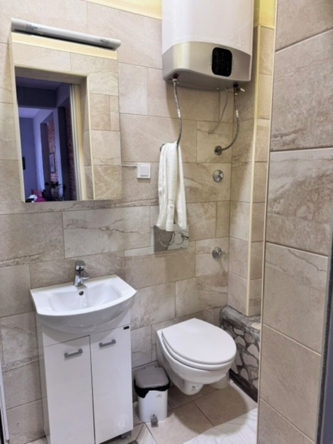 A bathroom with a sink, toilet, and shower.