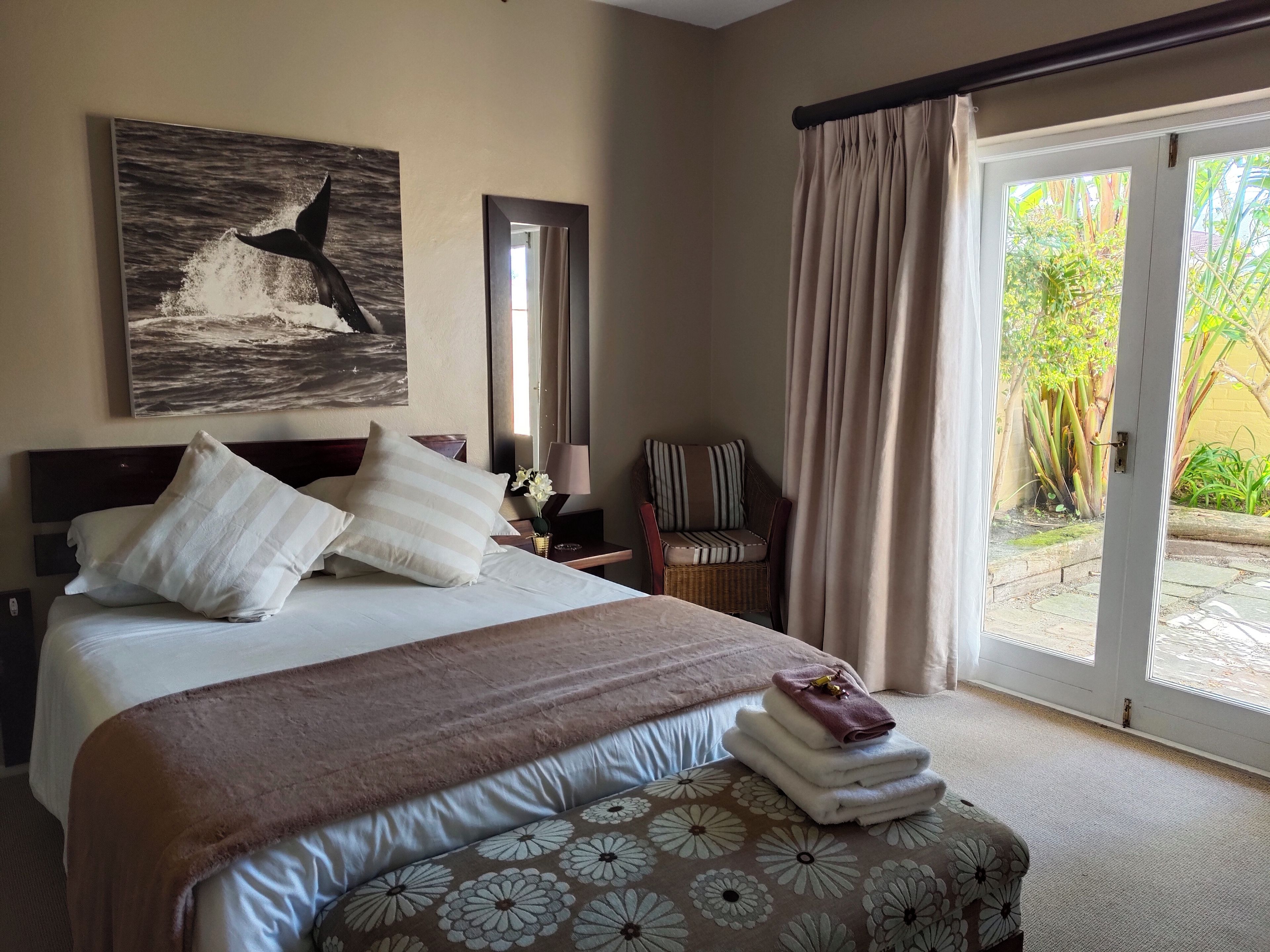 Une chambre d’hôtel avec un lit, une chaise, une fenêtre et une vue sur l’extérieur.