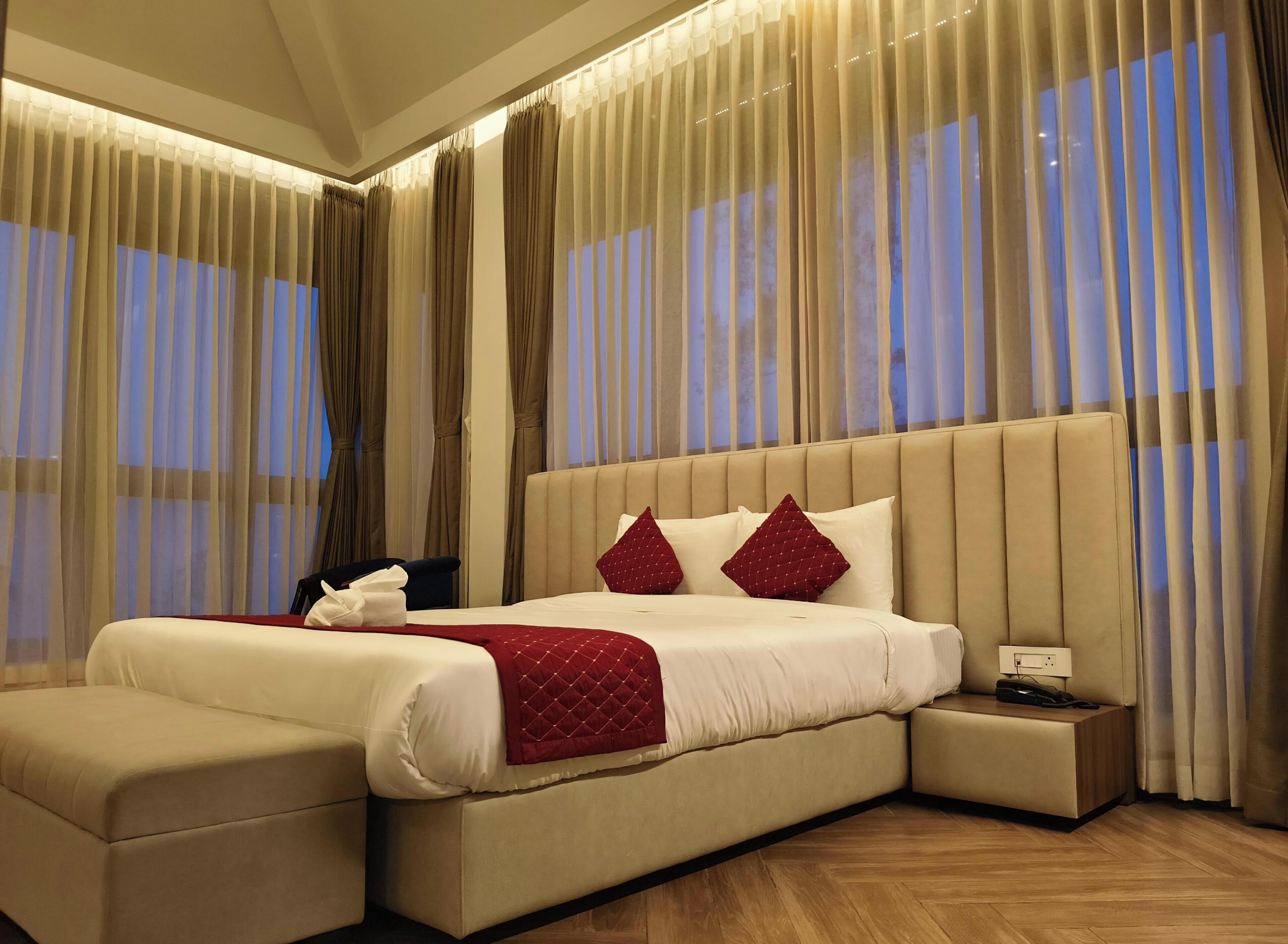 Une chambre spacieuse avec un grand lit, une table de chevet et une commode.