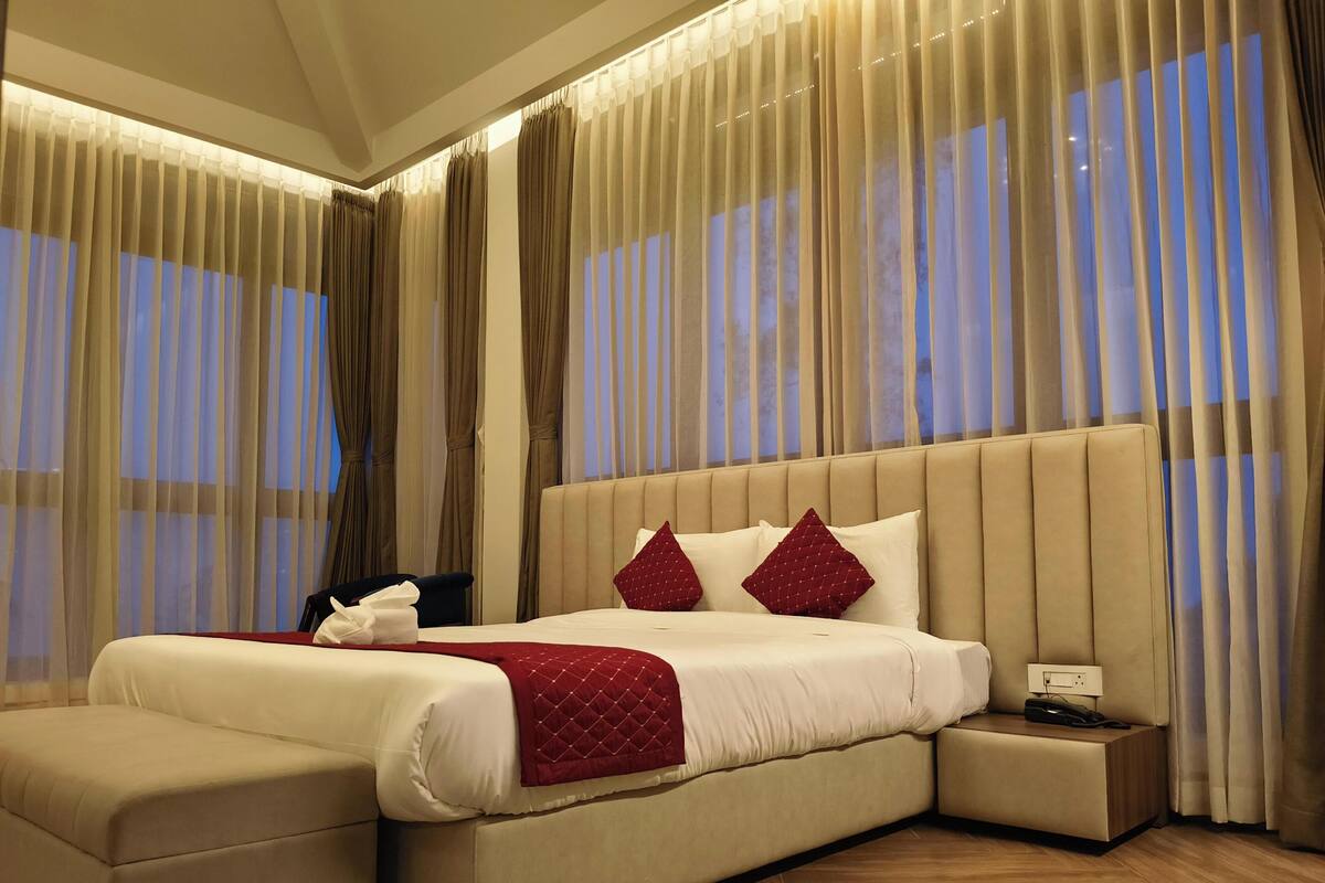 A spacious bedroom with a large bed, a bedside table, and a nightstand.
