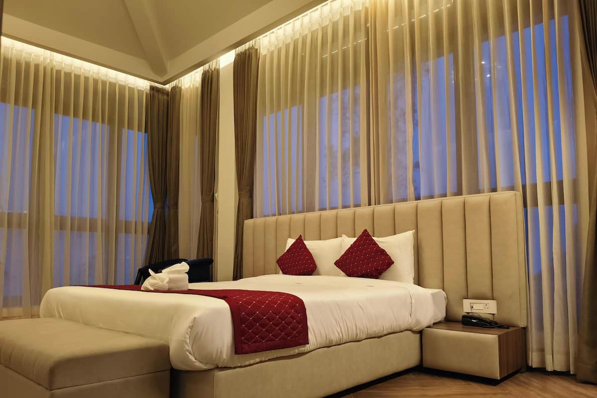 Une chambre spacieuse avec un grand lit, une table de chevet et une commode.