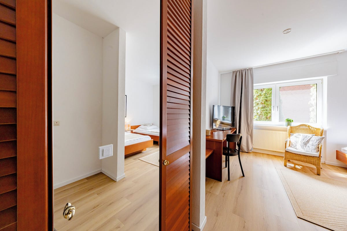 Un dormitorio con una cama, un escritorio y una silla.