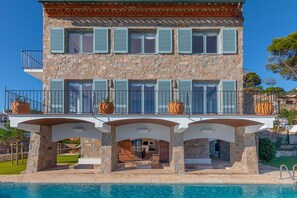 A two-story building with a pool, stone facade, and multiple balconies. - Villa Estasia front sea - My Rental Homes (Begur)