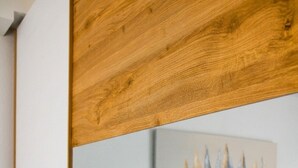 Un dormitorio con cama, un cuadro y cabecera de madera.