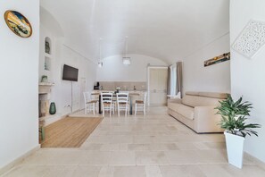 A modern interior with a dining area, kitchen, and living space. - DIMORA STUNE (Ostuni)