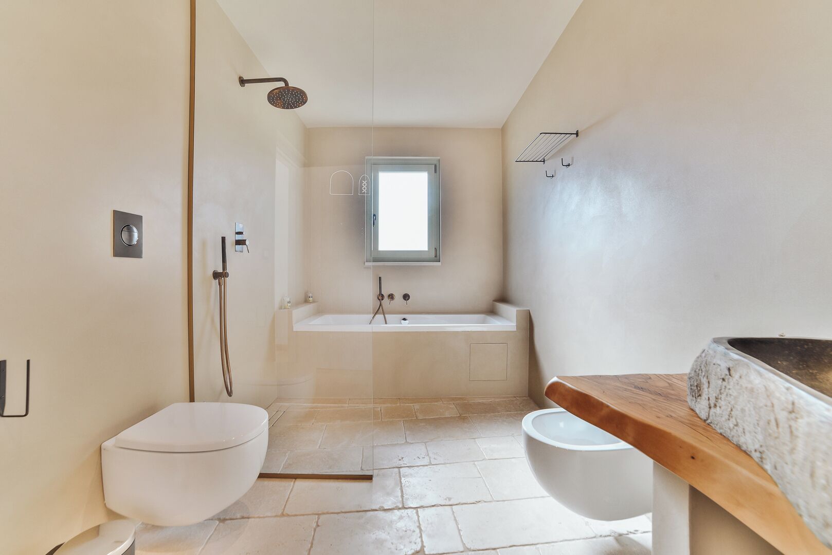 A modern bathroom with a toilet, shower, bathtub, and a window.