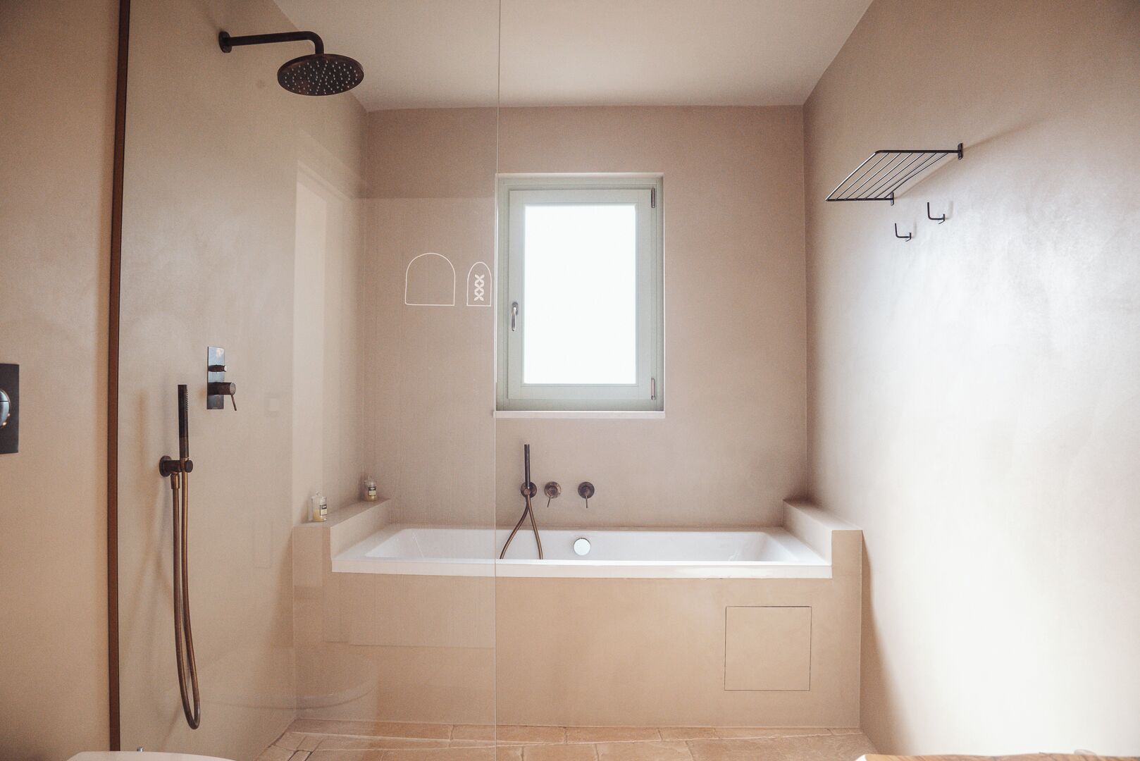 Ein Badezimmer mit Badewanne, Dusche und Fenster.
