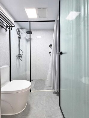 A modern bathroom with a toilet, shower, and glass partition. - Modern 1BR w/ pool, gym, dedicated workstation, restaurant and full backup power (Nairobi)