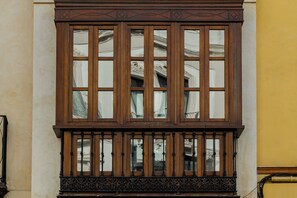 Ein großes Fenster mit mehreren Glasscheiben und einem verzierten Holzrahmen.