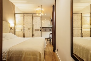 Ein Hotelzimmer mit zwei Betten, einem Schreibtisch und einem Spiegel.