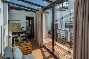 Ein modernes Wohnzimmer mit Glastür zum Balkon, einer Couch, einem Couchtisch und einem Bücherregal.