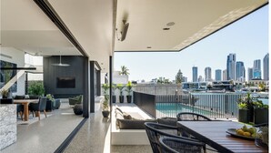 Un espace de vie moderne doté d’une piscine, d’un coin repas et offrant une vue sur les toits de la ville.