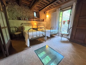 A rustic room with two metal beds, a stone wall, a small window, and a tiled floor. - Valentina apartment, at il Mulino Torrigiani (Capannori)