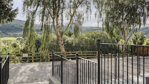 A gated entrance with a view of a hilly landscape and trees.