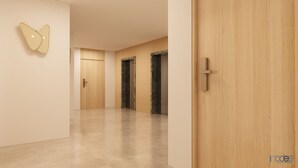 A modern hallway with a wooden door, a wall-mounted butterfly decoration, and a marble-clad elevator.