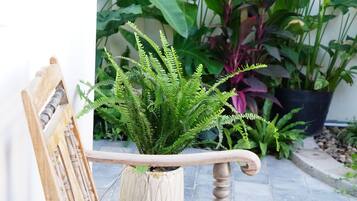 A wooden rocking chair with a potted plant beside it.