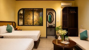 A hotel room with two beds, a sofa, a round coffee table, a mirror, and a wardrobe. - Tam Coc AppA House (Nam Hoa Lu)