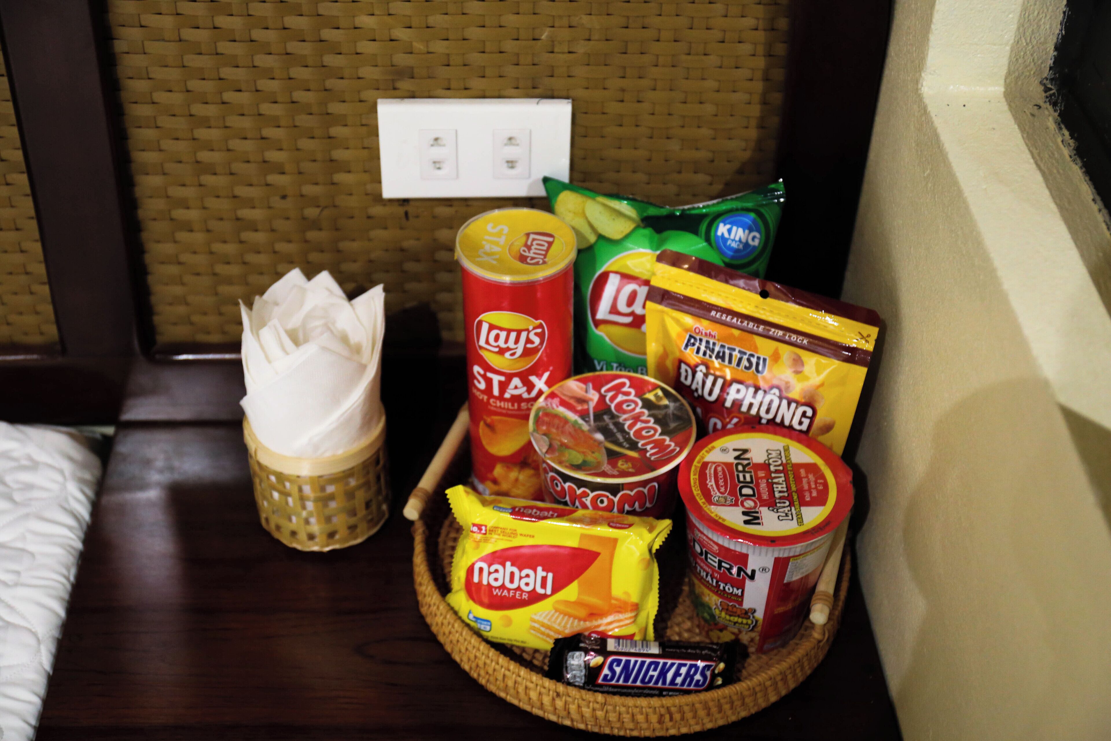 A tray with snacks including Lay's Stax, Lotte chips, and Nabati wafer.