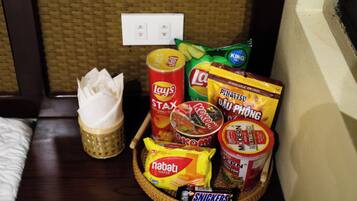 A tray with snacks including Lay's Stax, Lotte chips, and Nabati wafer.