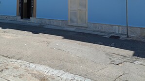 A building with a blue facade, a balcony with a metal railing, a door labeled 'Obreak 24,' and a street sign with 'via Diaz.' - Casa Vista Villa Room with Wi-Fi and Air Conditioning (Supersano)