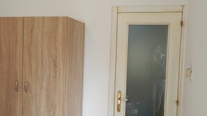 A room with a wooden wardrobe, a glass door, and an air conditioning unit on the wall. - Casa Vista Villa Room with Wi-Fi and Air Conditioning (Supersano)