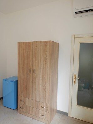 Ein Zimmer mit einem Holzschrank, einer blauen Aufbewahrungsbox und einer Vitrine.