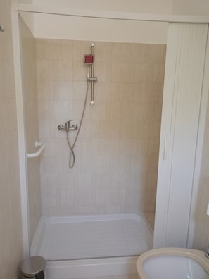 Ein Badezimmer mit Dusche, Toilette und Waschbecken.