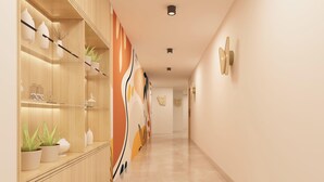 Un pasillo moderno con estanterías de madera, decoración en la pared y suelo pulido.