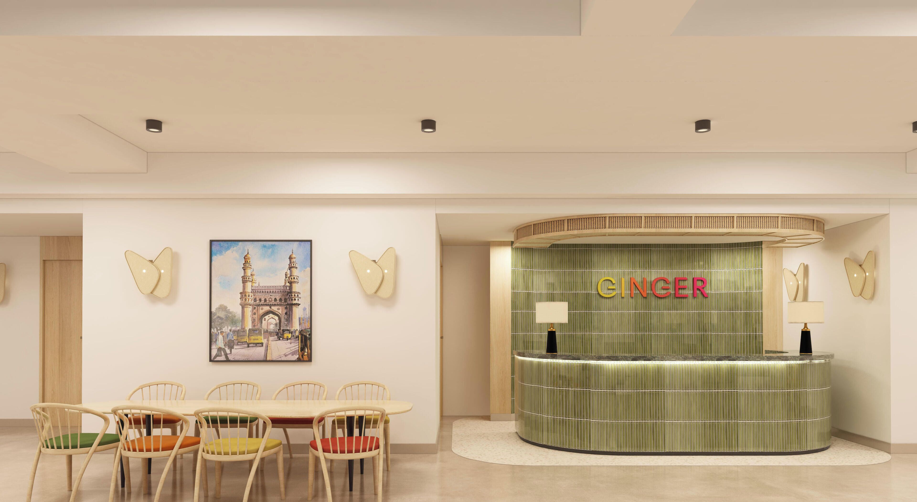 A reception desk with a green panel and the word 'GINGER' on it, surrounded by chairs and a framed picture on the wall.