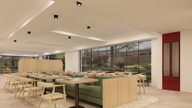 Un comedor moderno con una mesa larga, varias sillas y un sofá verde.