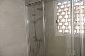 A glass-enclosed shower with a handheld showerhead and a wall-mounted faucet. - Agua Azul · Reformado · 5 Pax · Parking/wifi (Benidorm)