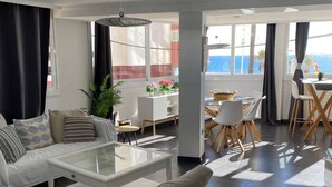 Una sala moderna con sofá, mesa de centro y comedor.