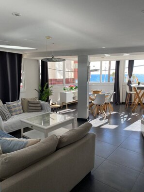 Ein modernes Wohnzimmer mit einer Couch, einem Couchtisch und einem Essbereich.
