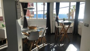 Una cocina moderna con comedor, ventanas amplias con vista al mar y un balcón.
