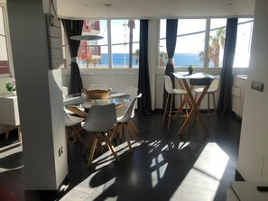 Eine moderne Küche mit Essbereich, großen Fenstern mit Meerblick und einem Balkon.