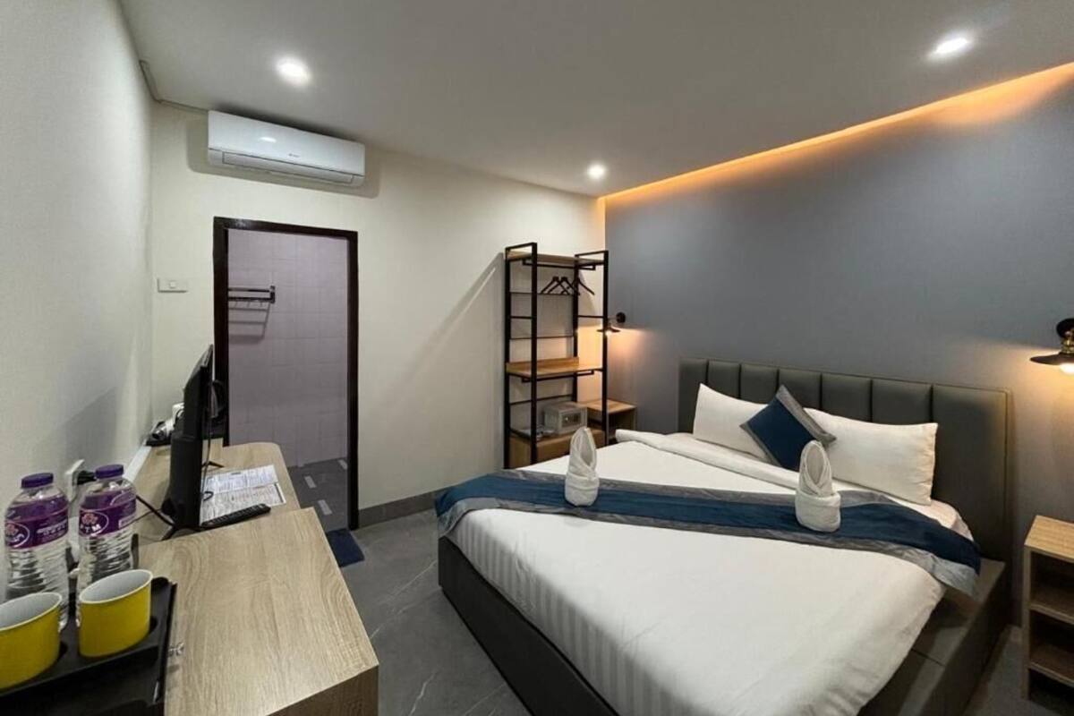 Une chambre d’hôtel comprenant un lit, une table de chevet, un bureau et une armoire.