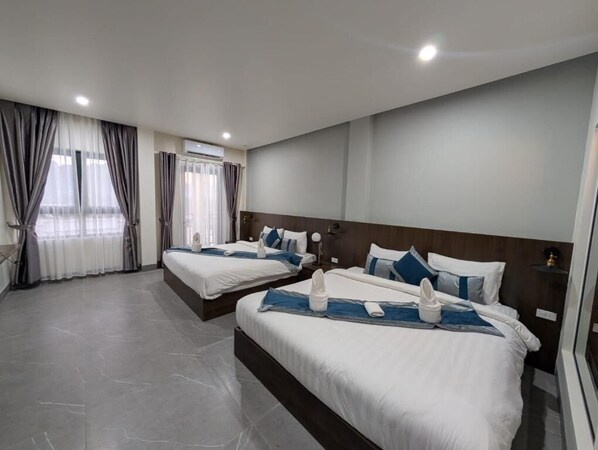 A hotel room with two beds, a large window with curtains, a wooden headboard, and a tiled floor. - Tulip Elegant Riverside Hotel (Vang Vieng)