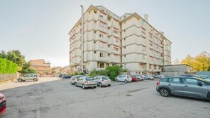 Un edificio residencial de varios pisos con un estacionamiento al frente.