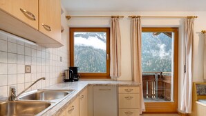 A kitchen with two sinks, a coffee maker, and a window with curtains. - Apartment 'Mair Am Tinkhof Bergwohnung' with Mountain View, Shared Terrace and Wi-Fi (Selva dei Molini)