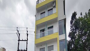 A multi-story building with balconies, large windows, and visible power lines. - Townhouse Aiims Kolkata Tanishq Inn (Kalyani)