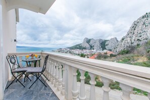 A balcony with a view of a coastal town and mountains. - Apartment Adriatic Panorama View (Omis)