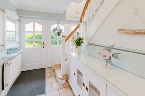A staircase leading to a landing with a view of greenery outside. - Inselhaus Bisdorf on Fehmarn - Apartment Ankerplatz (Fehmarn)